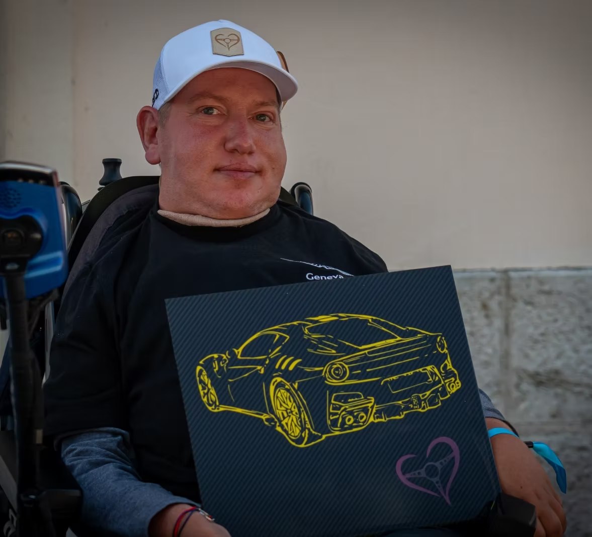 Cédric, casquette Cœur de Pilote, tenant une plaque carbone au trait jaune