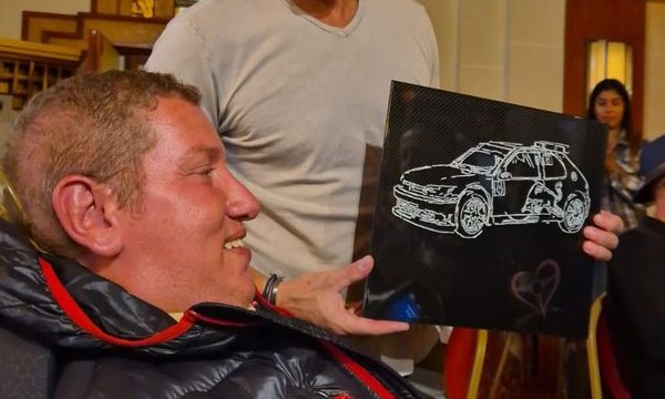 Cédric regarde une plaque carbone représentant une 306 Maxi